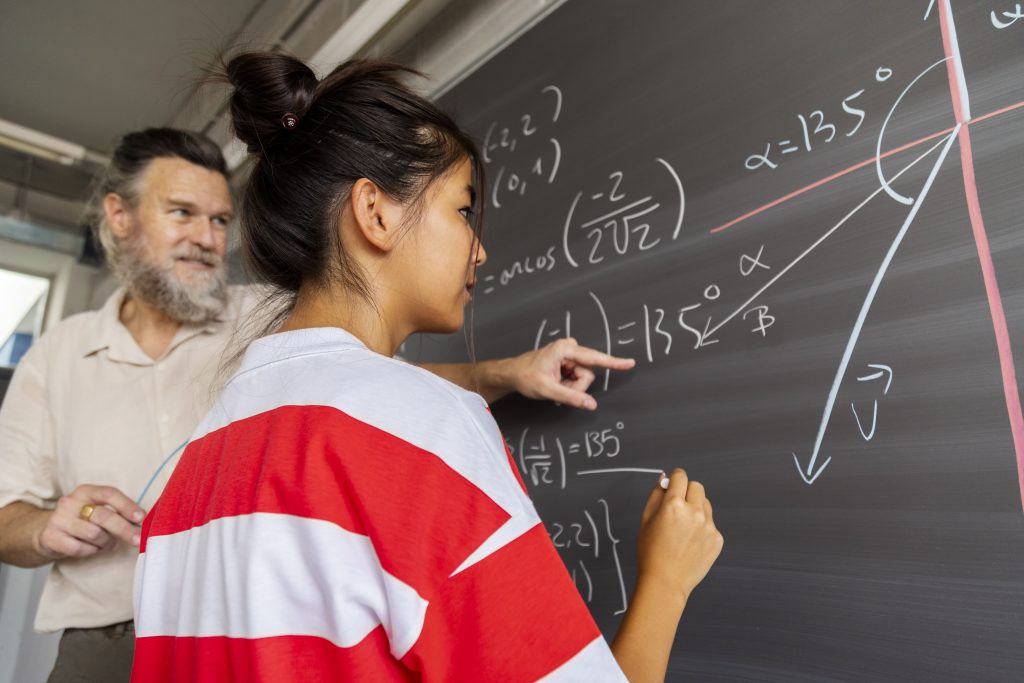 Alumno escribiendo en la pizarra en clase de matemáticas.