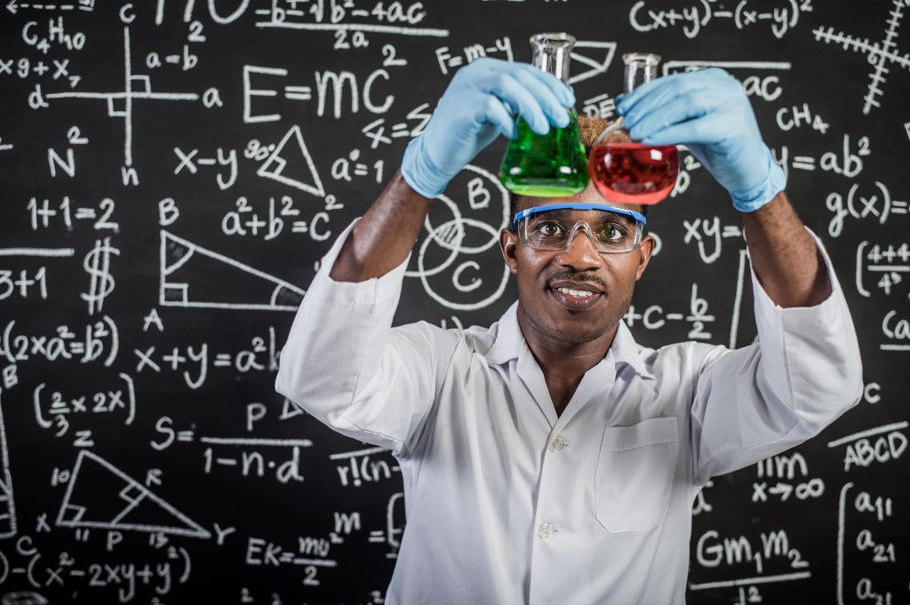 Profesor enseñando ecuaciones en la pizarra en clase de refuerzo.